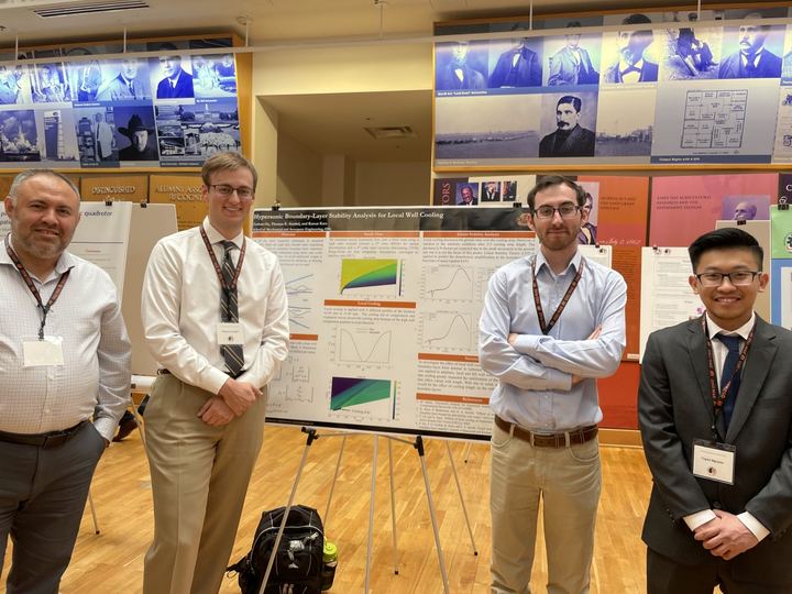 Kursat Kara with students beside a research poster